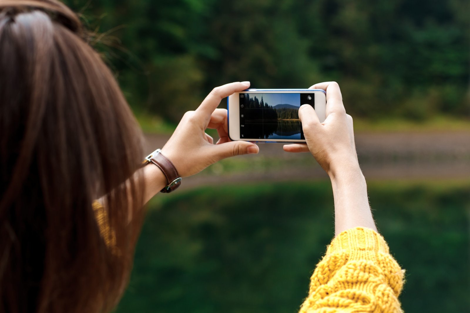 Une jeune dame prend une photo avec son smartphone